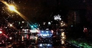 Out of focus image of a road through a rainy car window.