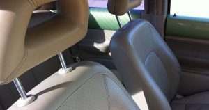 close up of the interior of a car with tan leather seats. 
