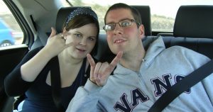 Two people in backseat of car with seat belts on